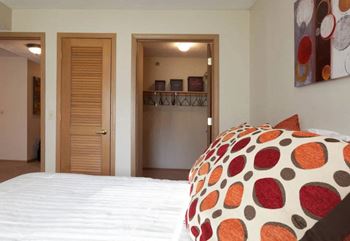a bedroom with a bed and a closet and a door to a bathroom